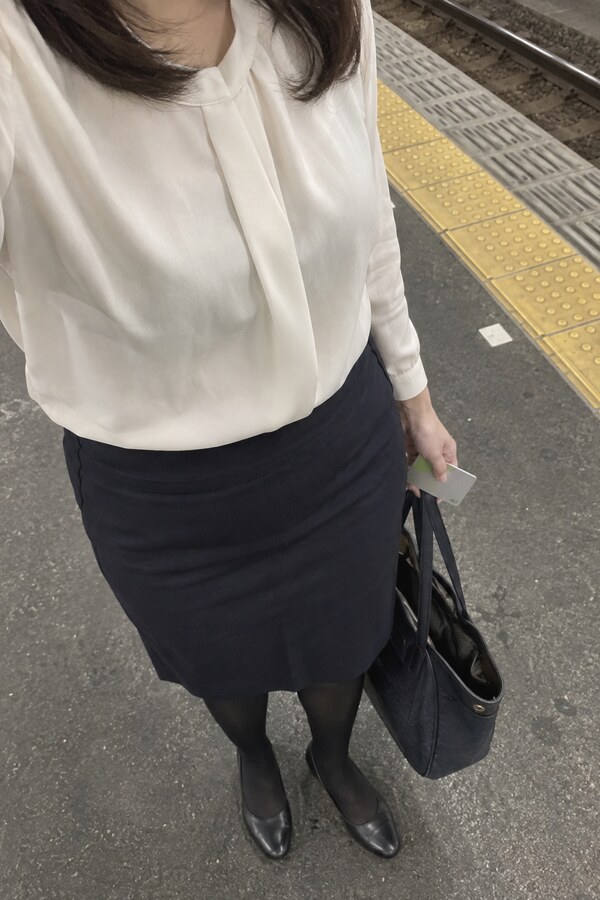 仕事帰りの駅で定期券と通勤バッグを左手に持つなみ